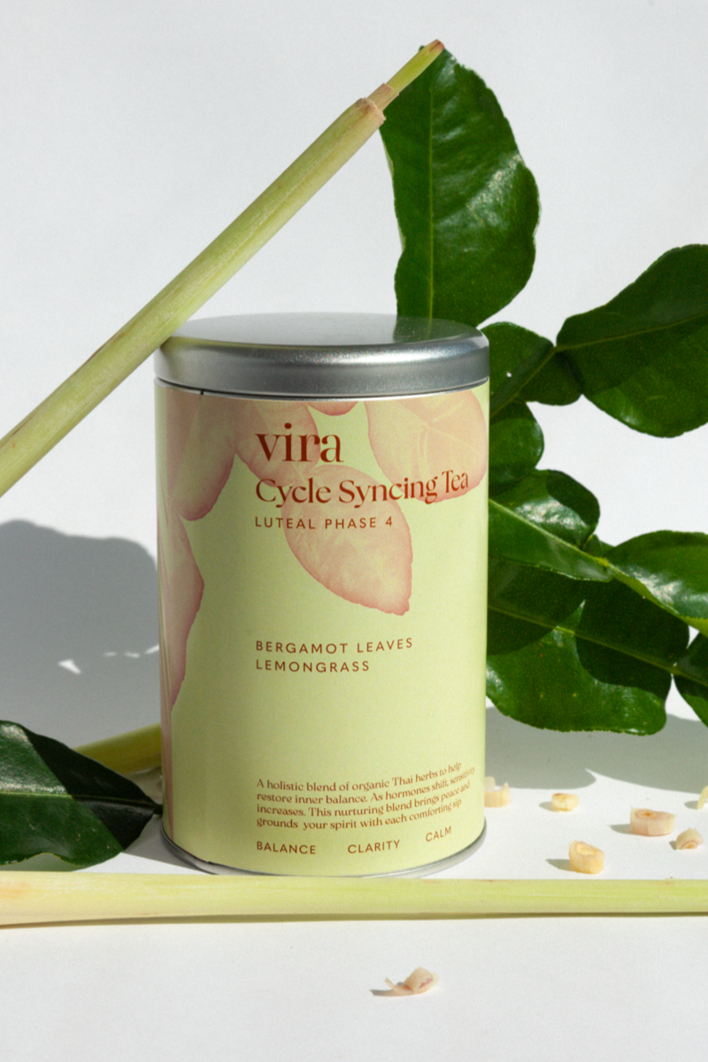 Vira Cycle Syncing Tea luteal phase canister with green leaves and plant elements on a light background